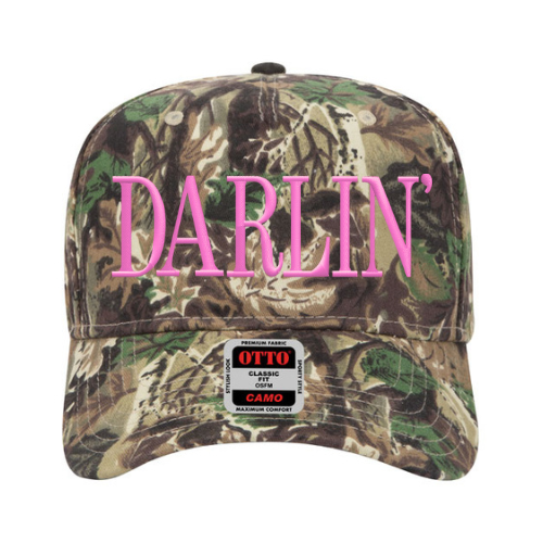 Custom embroidered camo hat with bold ‘Darlin’’ lettering in Bubble Gum Pink thread, mid-profile Otto cap style on a neutral background